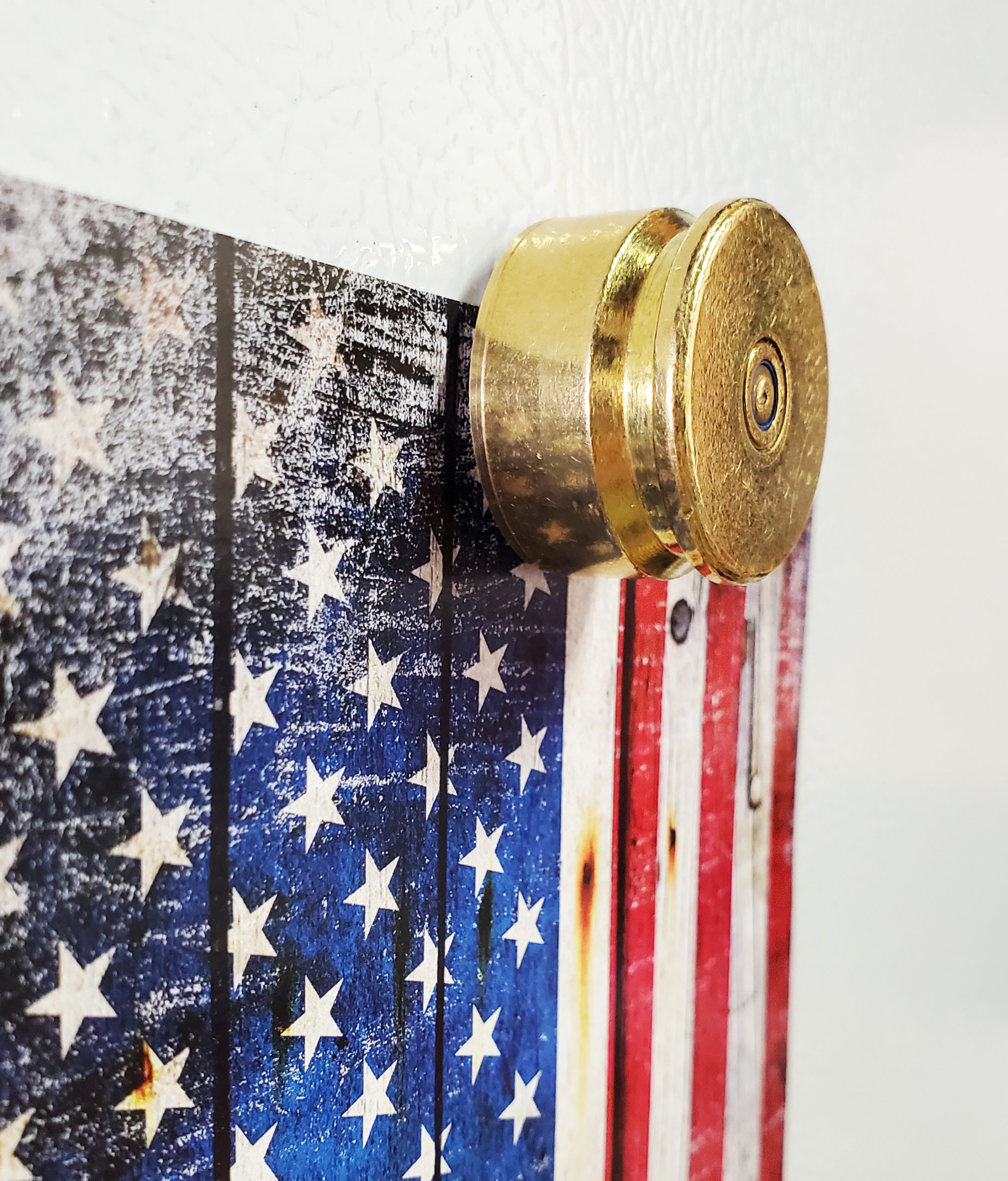 Brass magnets made with recycled casing of 20mm Vulcan cannon round holding card