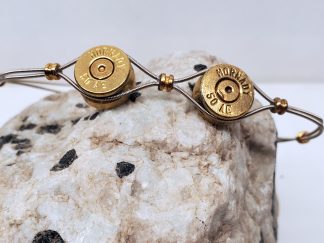 Double 50 AE Casings and Guitar Strings Unisex Bracelet on rock